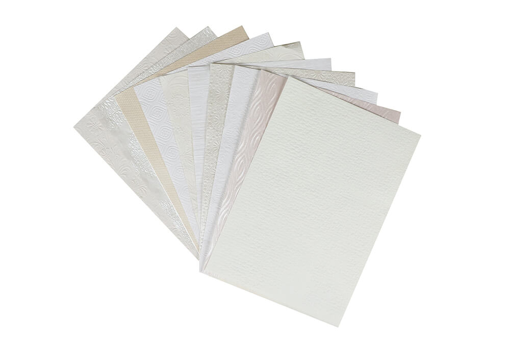 a pile of paper sheets showing different color & texture of textured paper