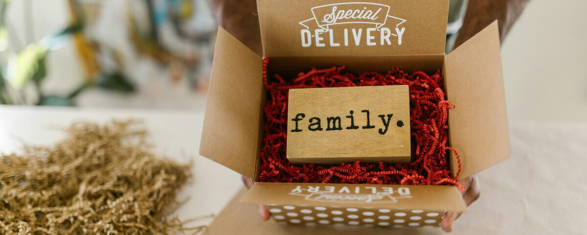 Kraft gift boxes labeled “Special Delivery” with red filler and a wooden “family” block inside