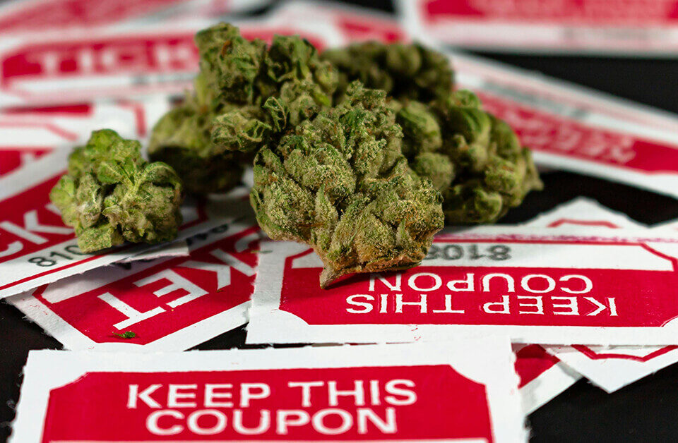 Cannabis buds on top of medical marijuana labels with "KEEP THIS COUPON" text