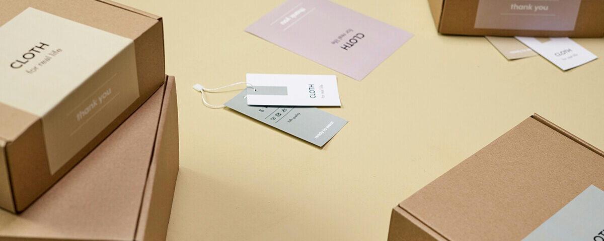 the best packaging inserts ideas: Kraft paper clothing packaging with minimalist tags and thank-you card inserts
