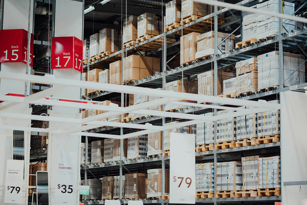 Shelves in a store warehouse displaying stacked packaged products.