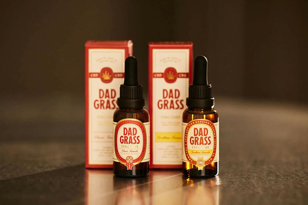 Branded Dad Grass THC tincture bottles with matching retail boxes.