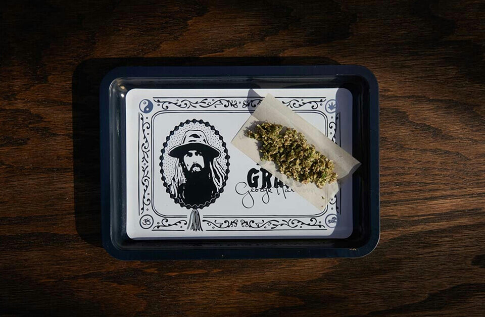 Black and white weed rolling tray with George Harrison illustration and a joint in progress