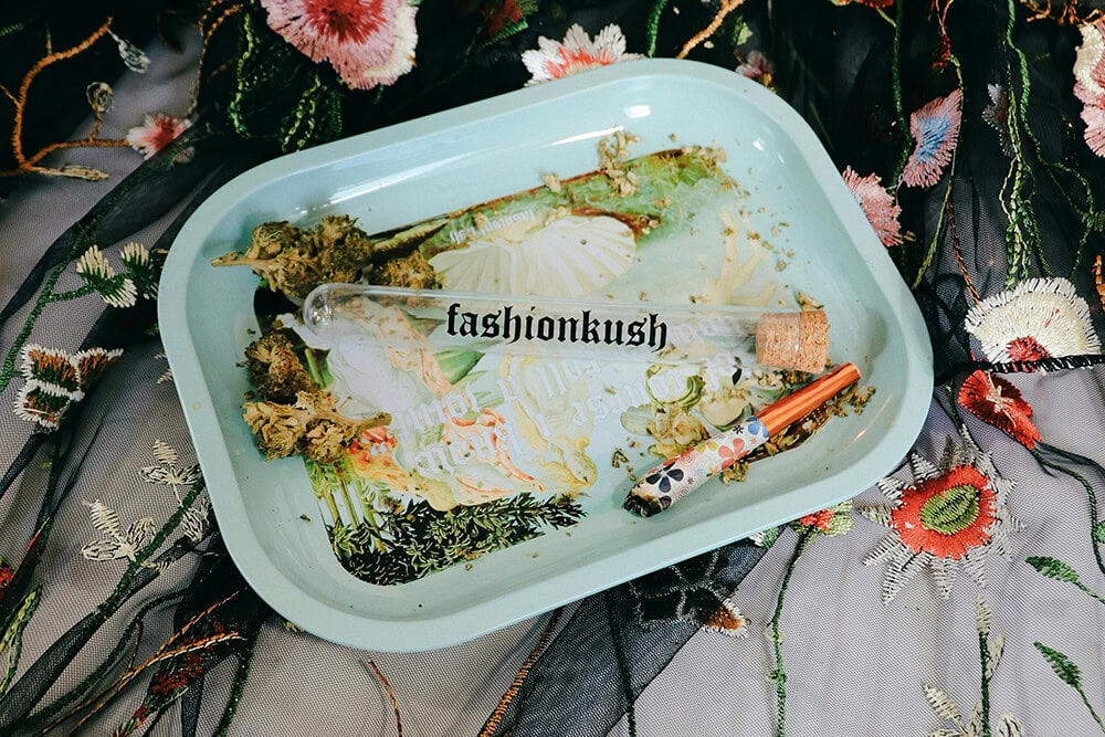 Light green decorative weed rolling tray with floral accents and cannabis tools.