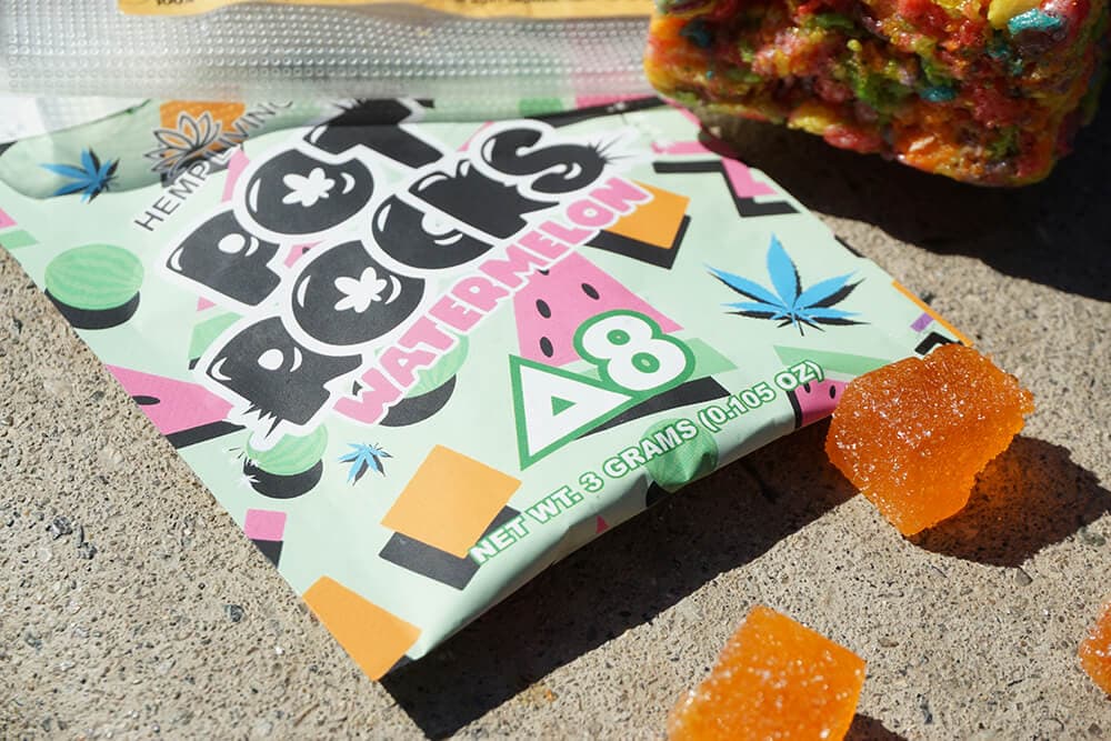 Delta 8 edible packaging with bright weed stickers on a Pot Rocks pouch.