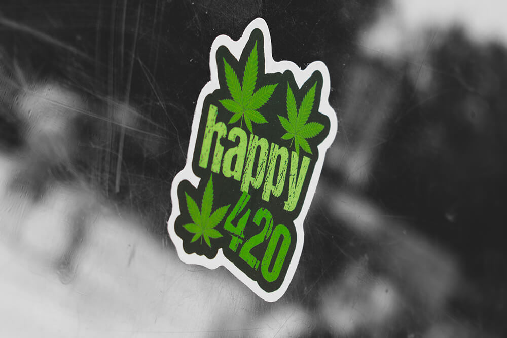 A green "Happy 420" weed sticker featuring cannabis leaves.
