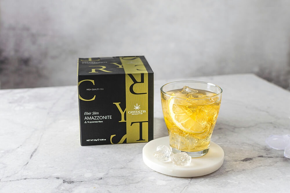 Crysta Tea Amazzonite CBD tea box with a glass of iced tea and lemon.