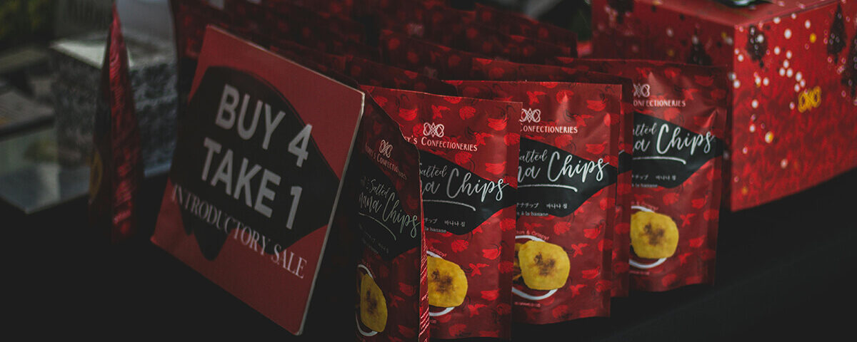 custom packaging services: red custom food packaging pouch for banana chips with promotional display