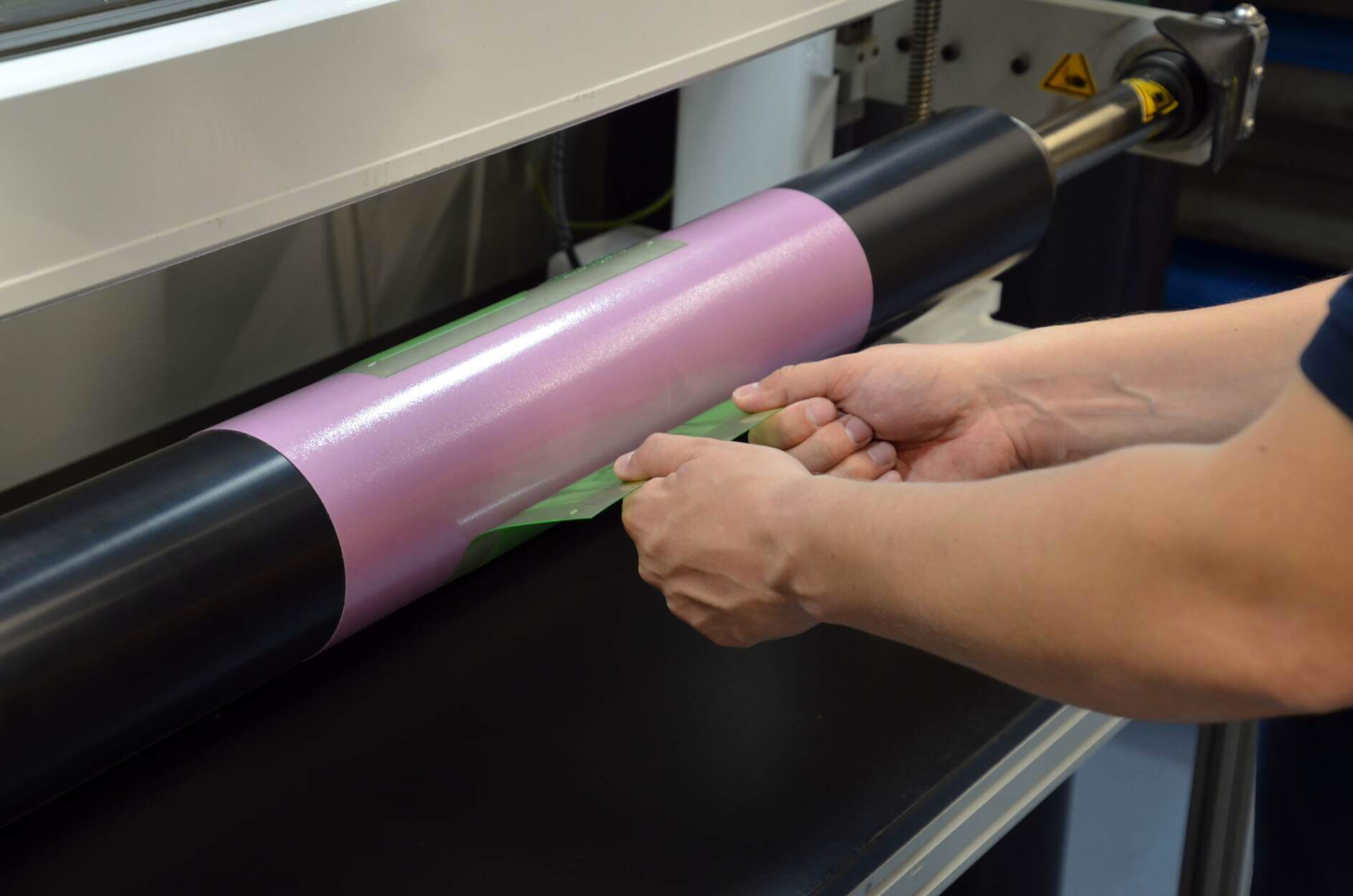 a man runs a flexographic printing machine
