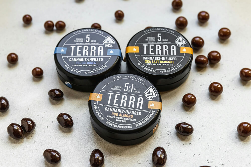 Assorted Terra cannabis-infused chocolate edibles in branded round tins.