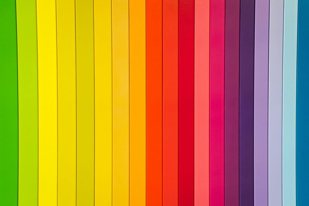 Multi-colored paper strips arranged in a spectrum from green to blue