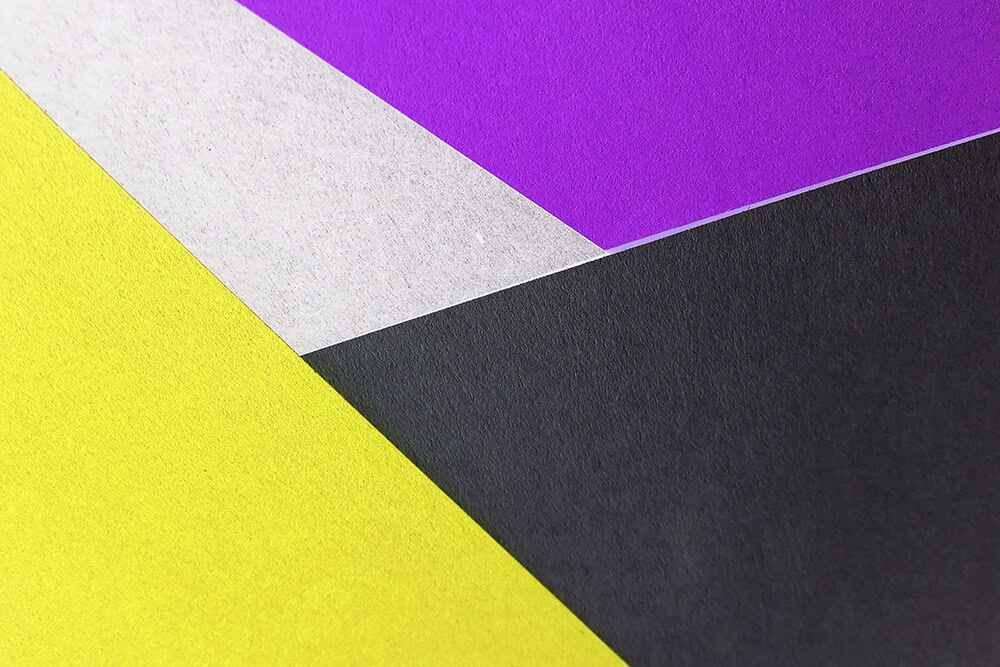 Textured paper sheets in purple, yellow, black, and silver tones