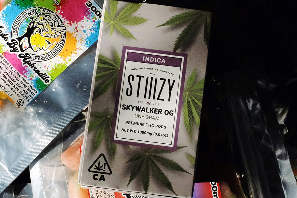 Branded cardboard packaging for cannabis vape pod with marijuana leaf design.