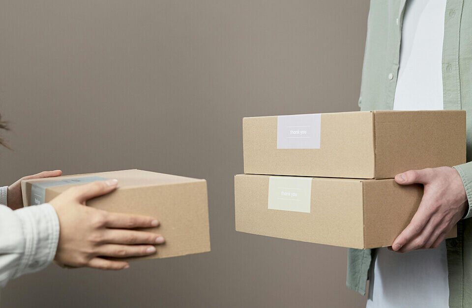 mailer box design ideas showingTwo people exchanging custom mailer boxes for delivery