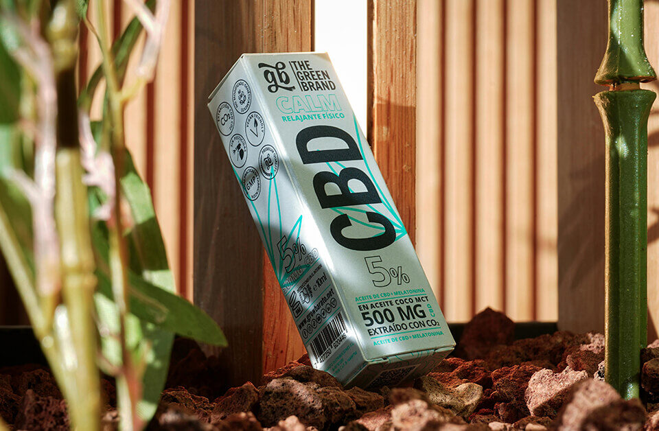 custom CBD packaging box displayed outdoors among natural plants.
