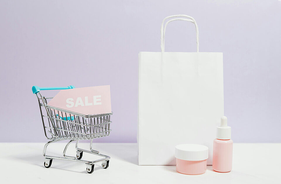 Minimal white custom retail packaging bag with beauty products and a mini shopping cart on a pastel background.