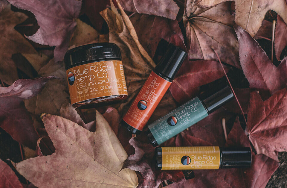 CBD-infused products, including a Blue Ridge Hemp Co. CBD relief stick, surrounded by autumn leaves.