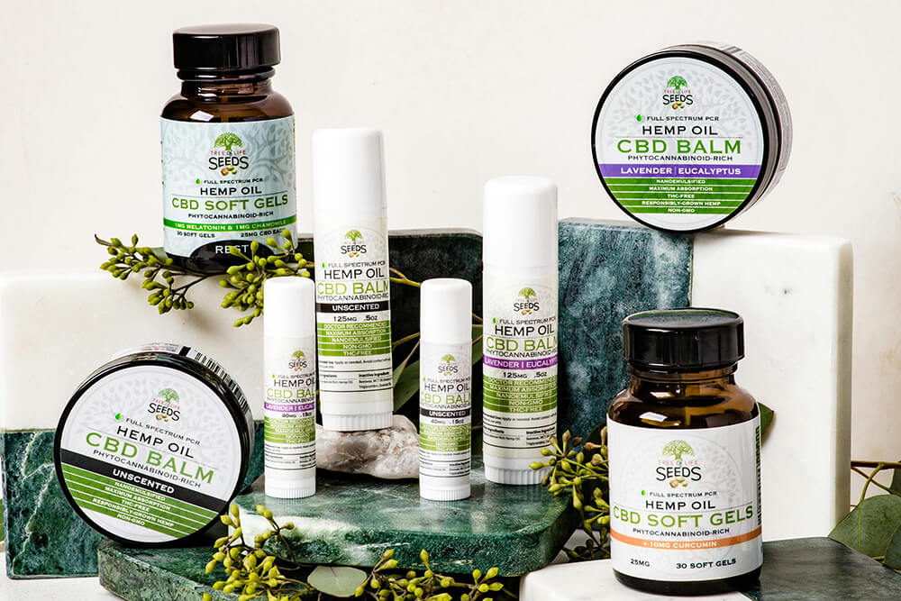 A selection of CBD relief sticks and soft gels from Seeds with labels showcasing full-spectrum hemp oil.