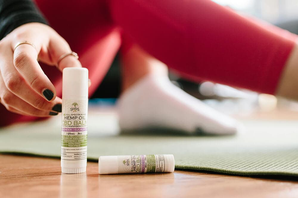 A person using a CBD relief stick after a workout session for muscle relief and recovery.