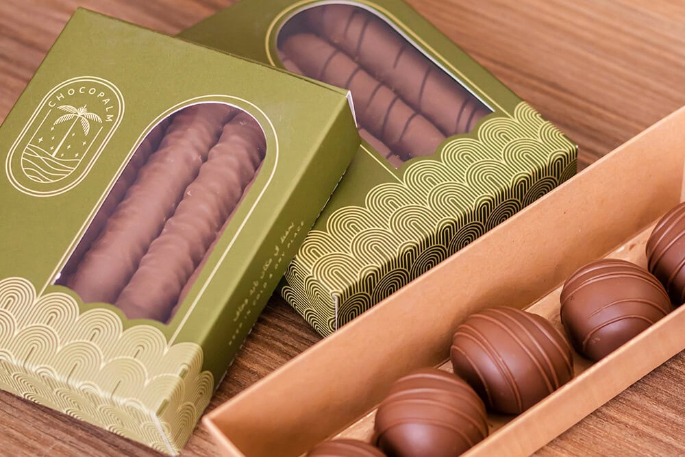 Windowed truffle box packaging displaying chocolate truffles in an inner tray