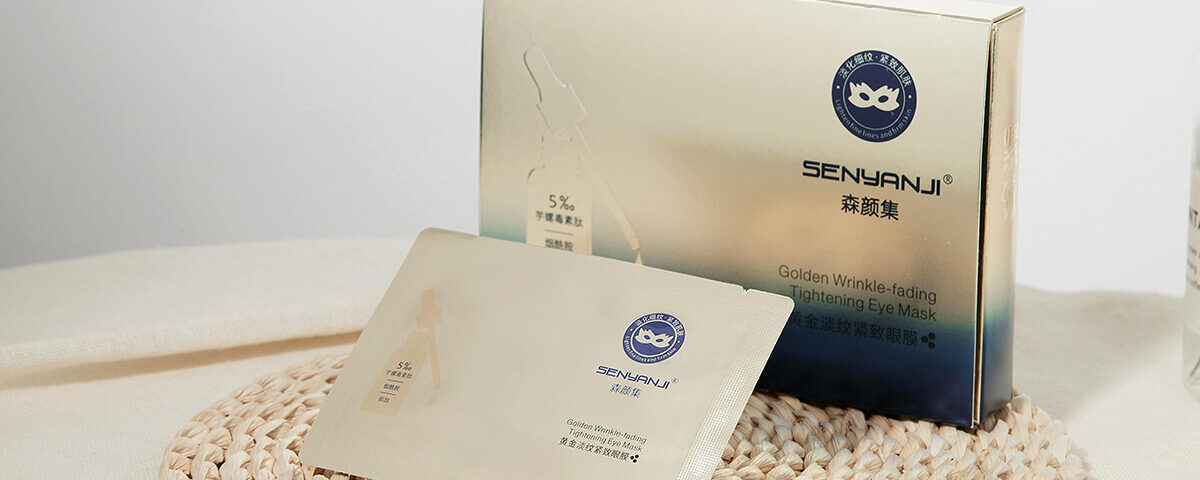 Gold metallic rigid box and matching sachet for eye masks, exemplifying high-end luxury packaging boxes with foil finishes