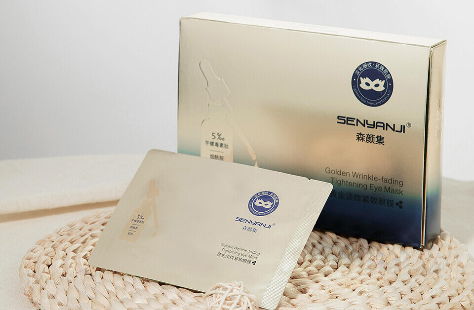 Gold metallic rigid box and matching sachet for eye masks, exemplifying high-end luxury packaging boxes with foil finishes