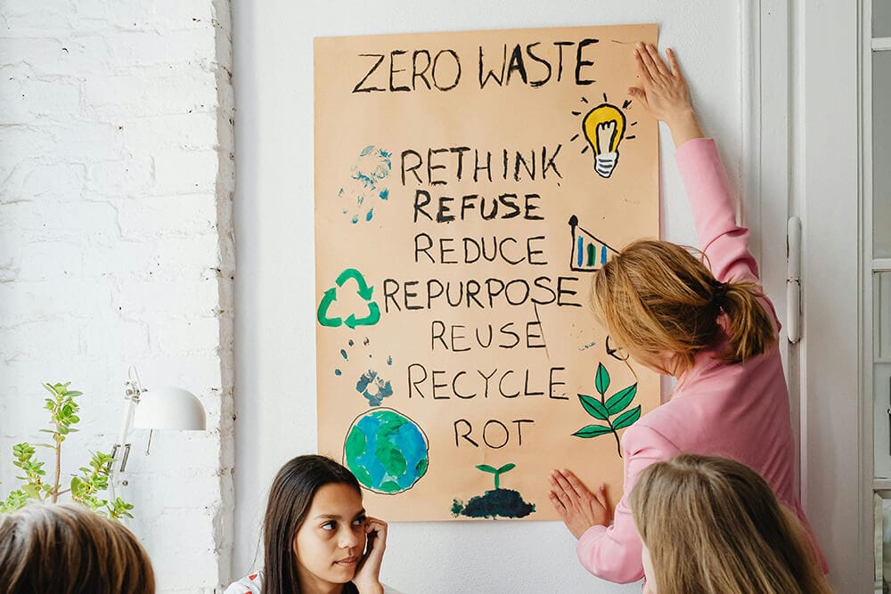 A "ZERO WASTE" poster being mounted on a wall, listing the seven Rs: Rethink, Refuse, Reduce, Repurpose, Reuse, Recycle, and Rot, as part of a sustainable cannabis packaging strategy.