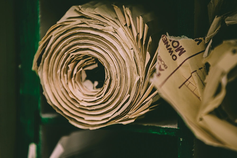 A close-up of a large roll of recycled kraft paper, a primary material used for sustainable cannabis pre roll packaging and secondary boxes.
