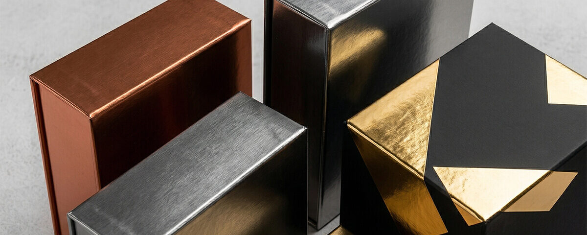 Arrangement of customized copper, silver, and matte black cannabis metallic boxes.