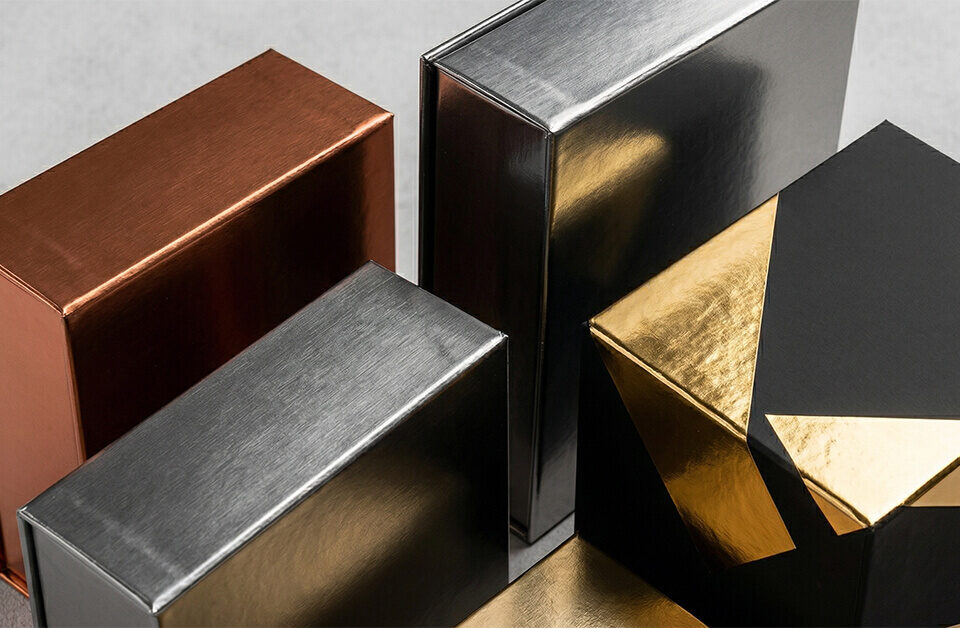 Arrangement of customized copper, silver, and matte black cannabis metallic boxes.